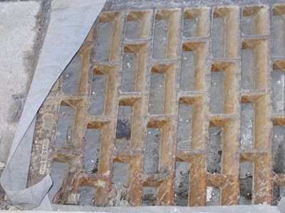a sewer grate purposefully obfusctad by a sheet of plastic