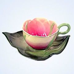 a teacup and saucer designed to look like a lotus leaf and flower