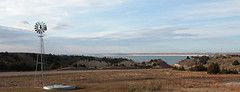 a picture of a windmill, the Nebraska Sandhills, and Lake McConaughy in the distance