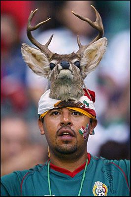 a Mexican soccer fan with a imitation buck deer head strapped to his own head