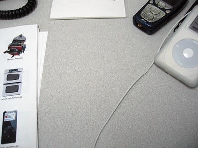 things on a desk: printed images, a nokia cell phone, an iPod