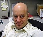 a selfie taken by a bald man in a cubicle