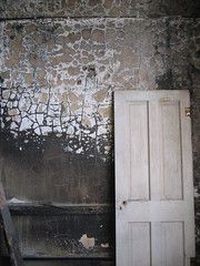 a wall that has seen fire and a white door