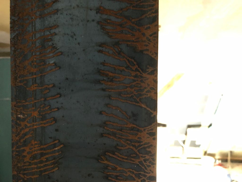 a steel beam with lines of organic/vegetal rust