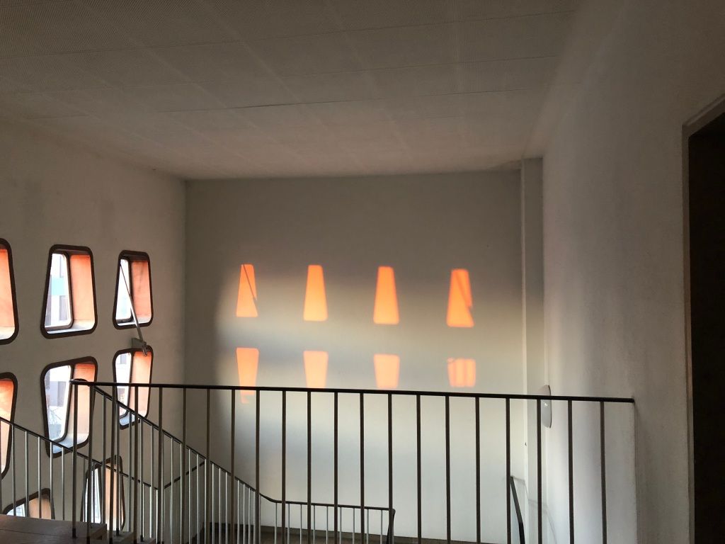 orange light through oddly shaped windows in a stairwell