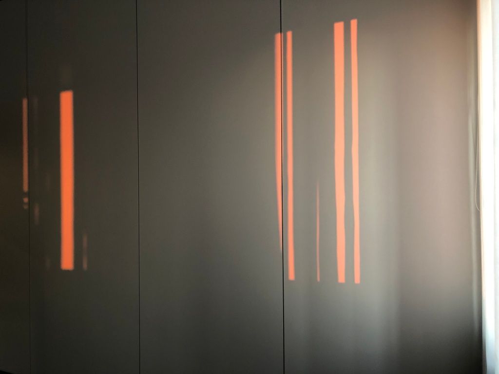 orange light through venetian blinds onto a white wall