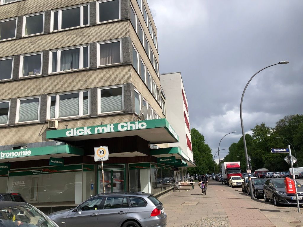a several storey brick building with businesses on the ground floor. the business on the corner of the building is called "dick mit Chic."