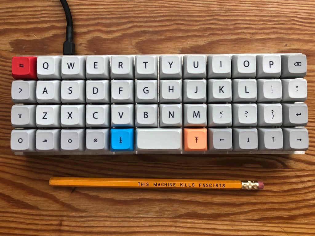 a Planck keyboard and a pencil upon which is printed "THIS MACHINE KILLS FASCISTS"