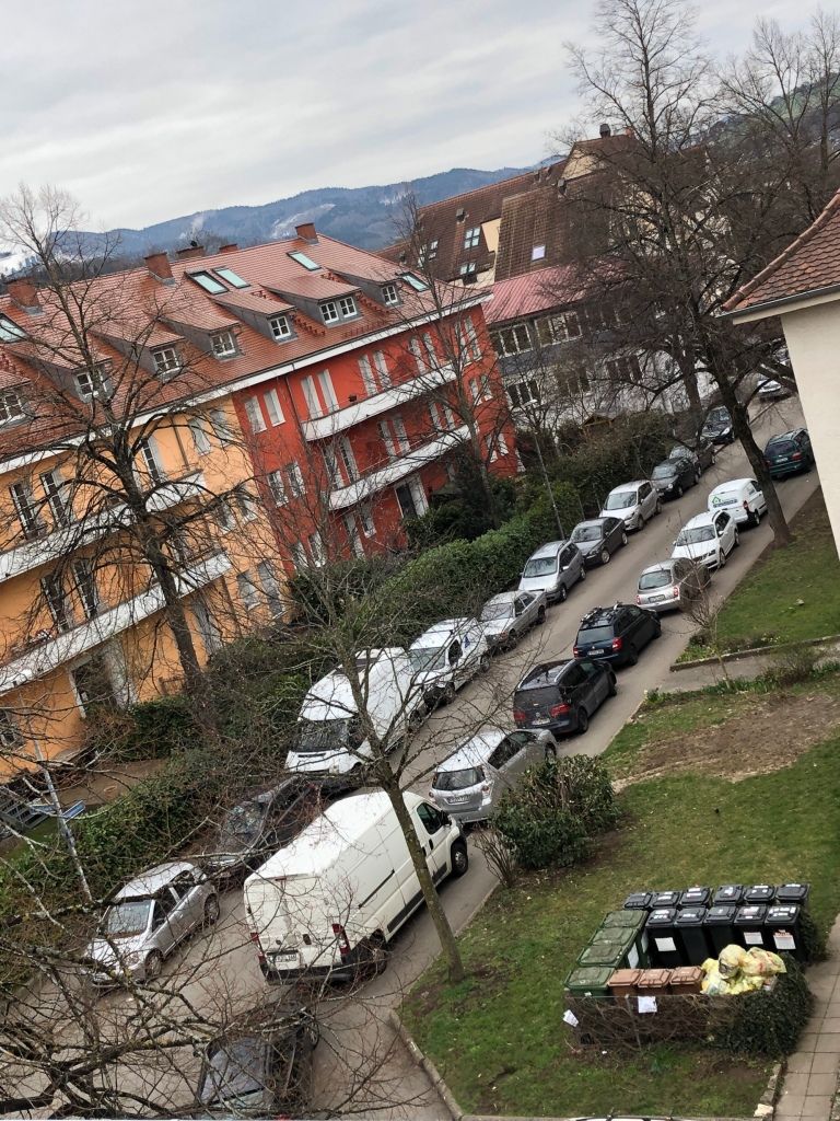 a street where all the cars on the far side and most of the cars on the near side are a shade of gray