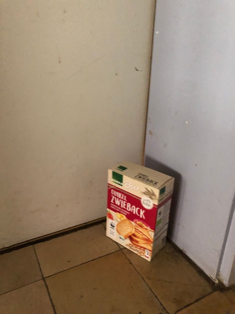 a box of Edeka bio Dinkel Zwieback in the corner of a rather squalid-looking room